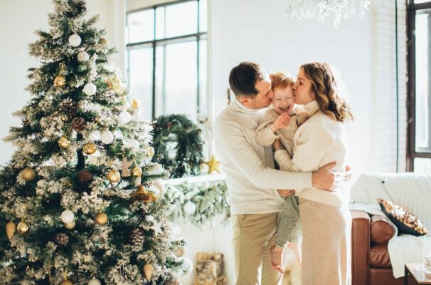 Family embracing in front of a Christmas tree